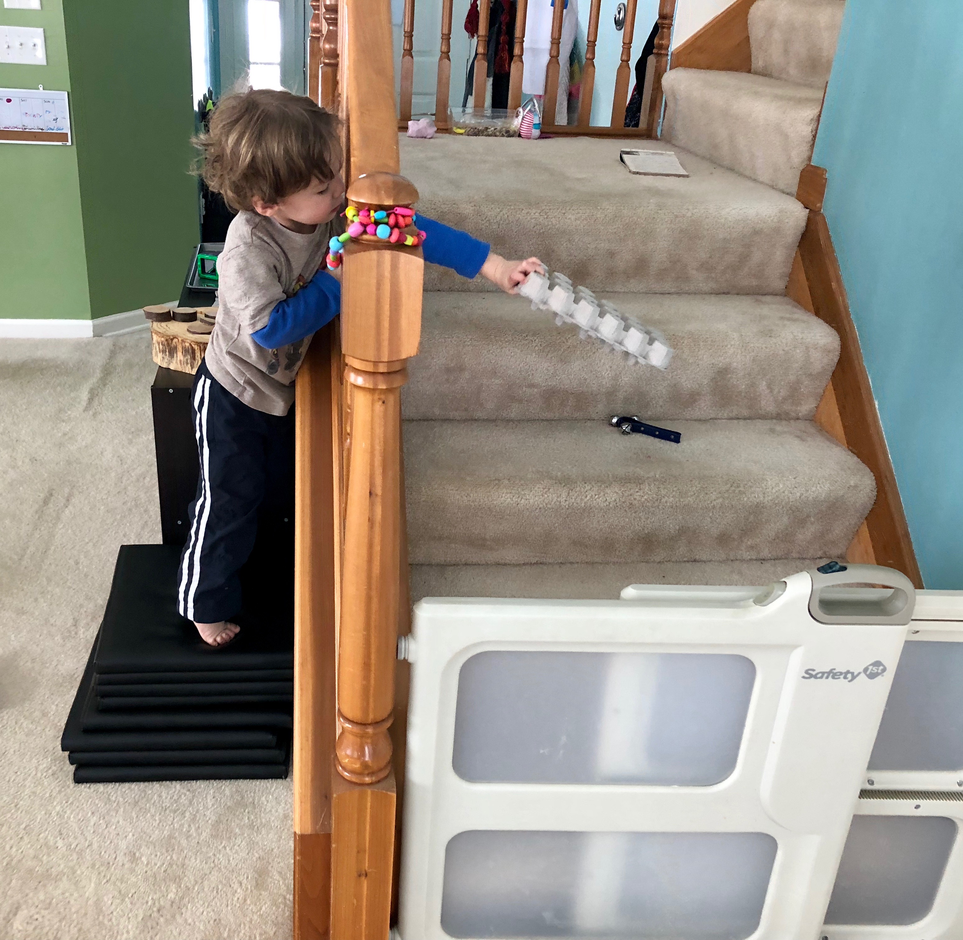 boy trying to grab bell on the stairs with an egg carton