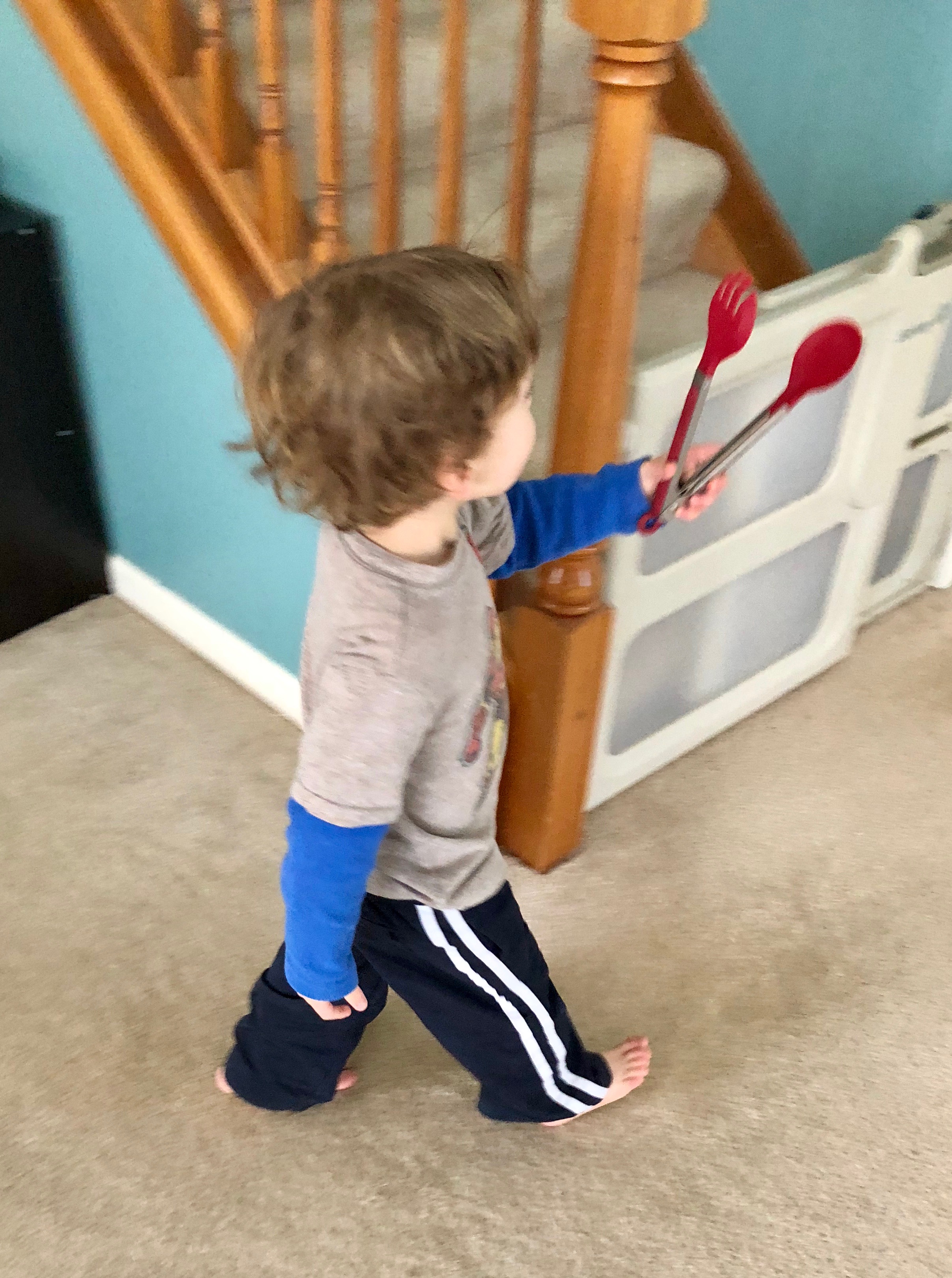 boy carrying kitchen tongs