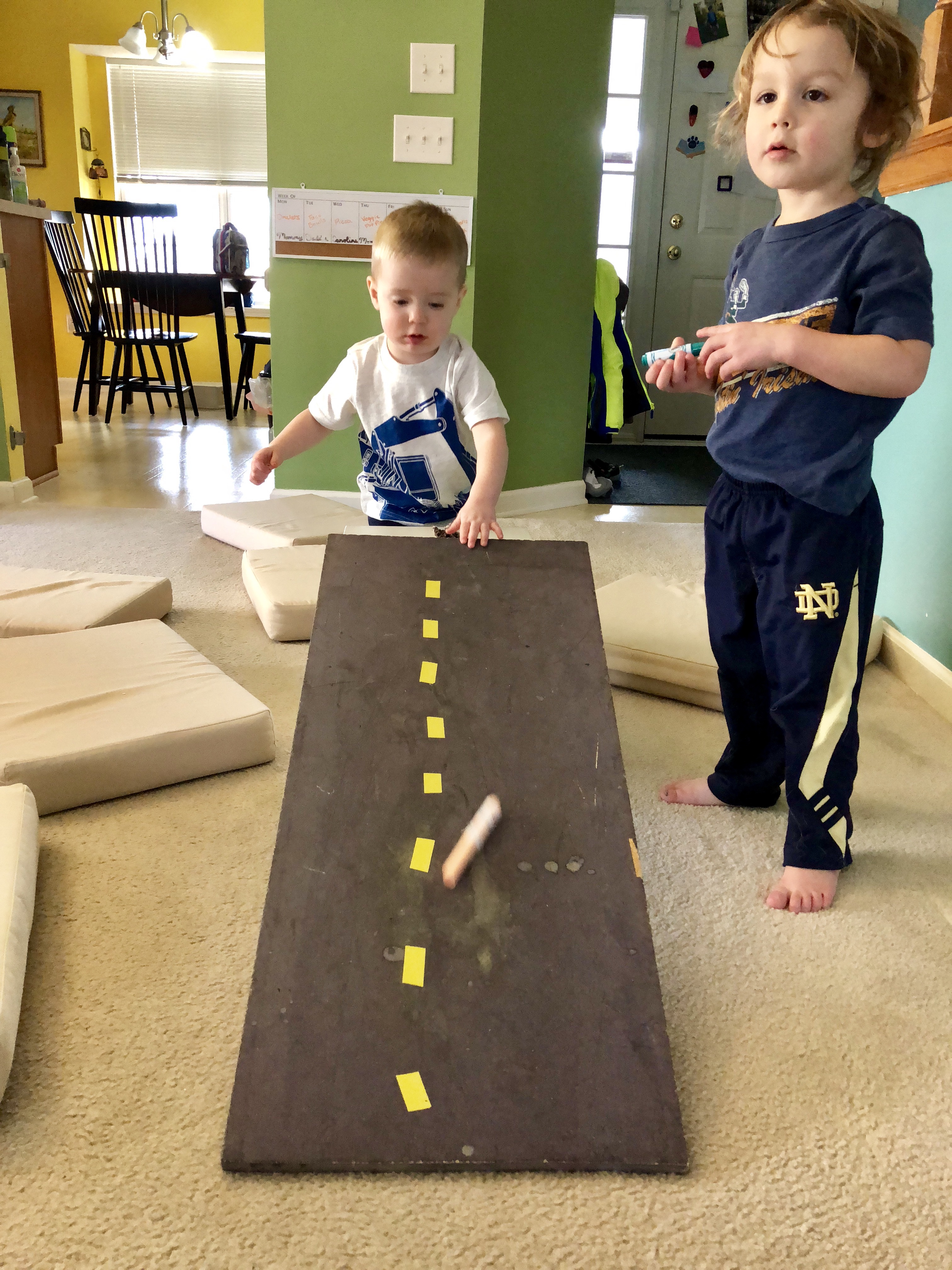 boy rolling a marker down a ramp