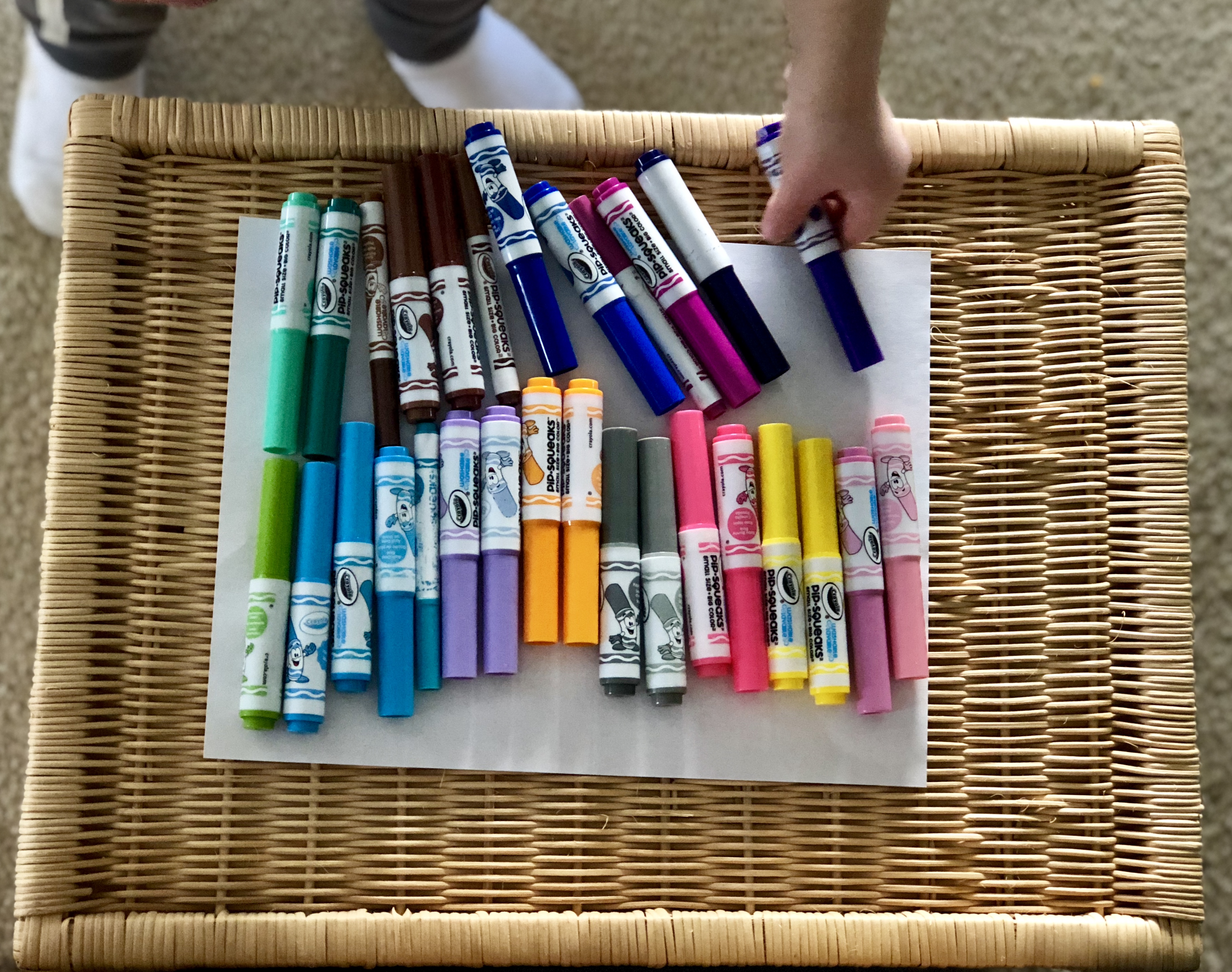 child's hands lining up matching colors of markers