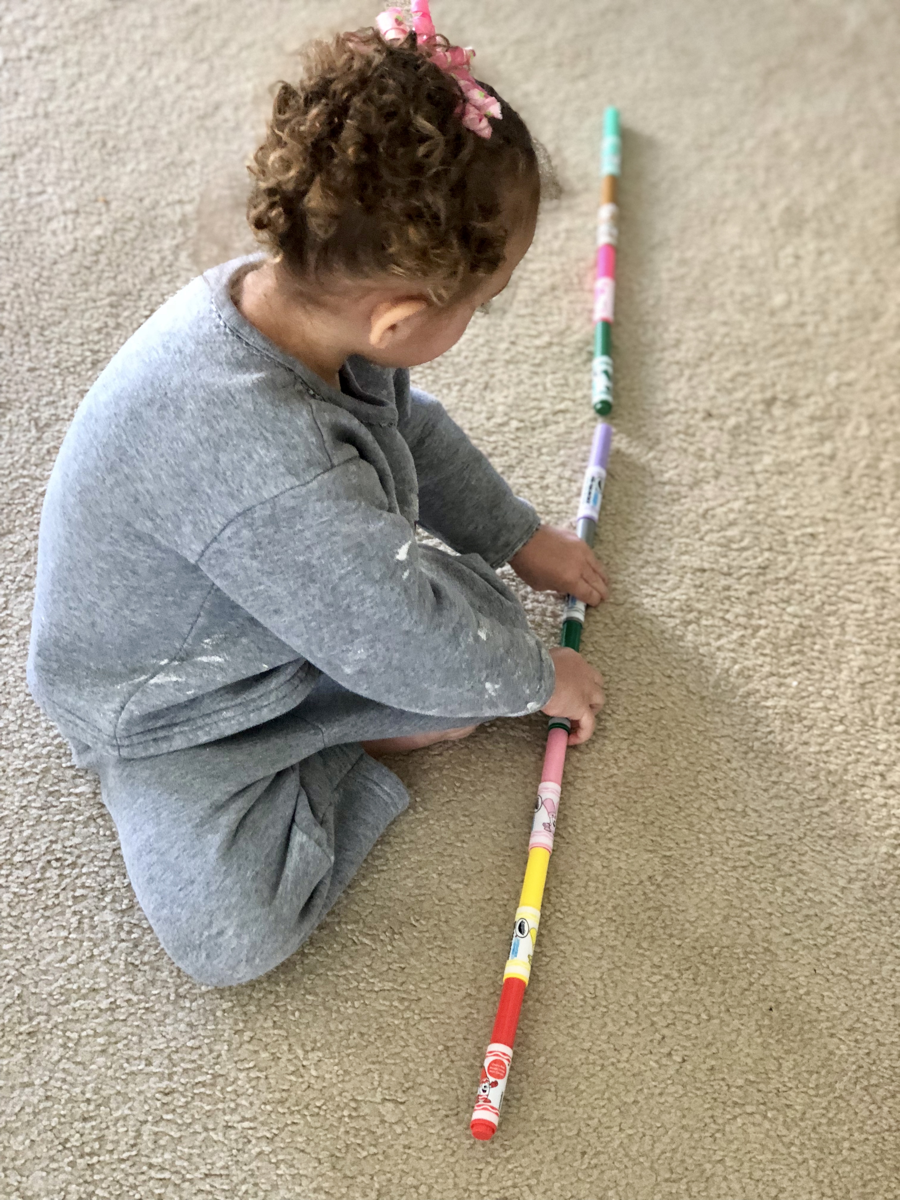 girl lining up markers and connecting them on the floor
