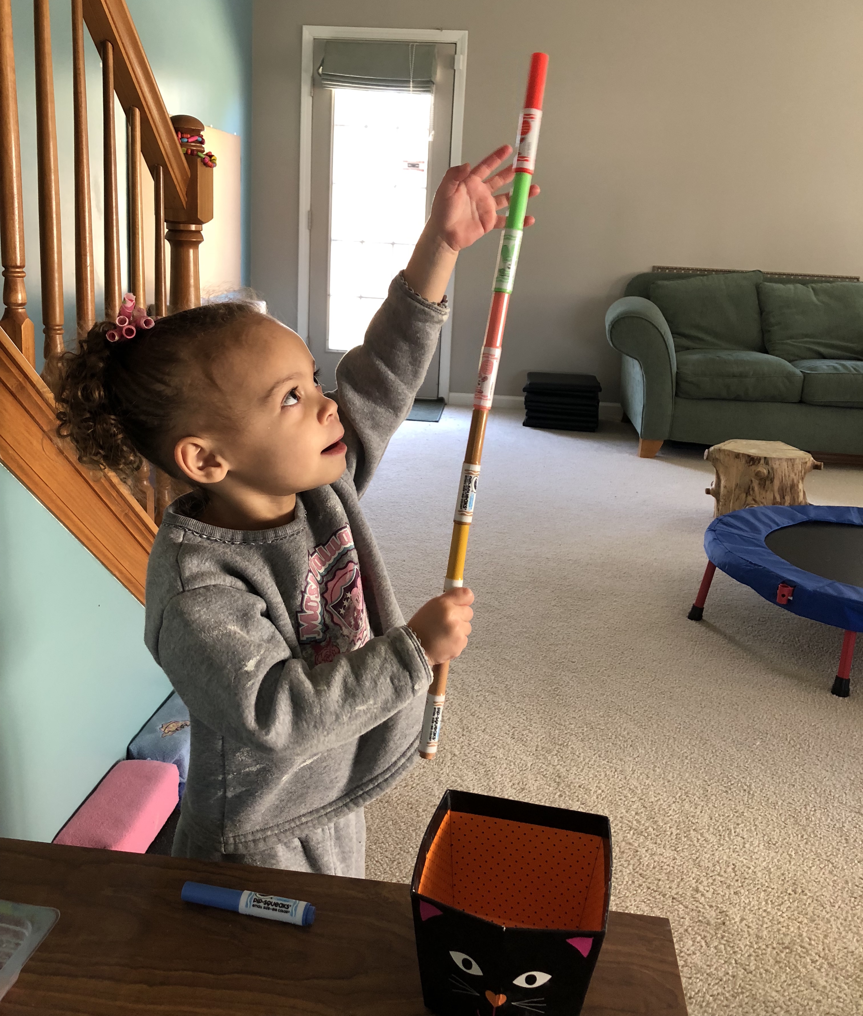 girl holding onto a marker tower from the top and the bottom