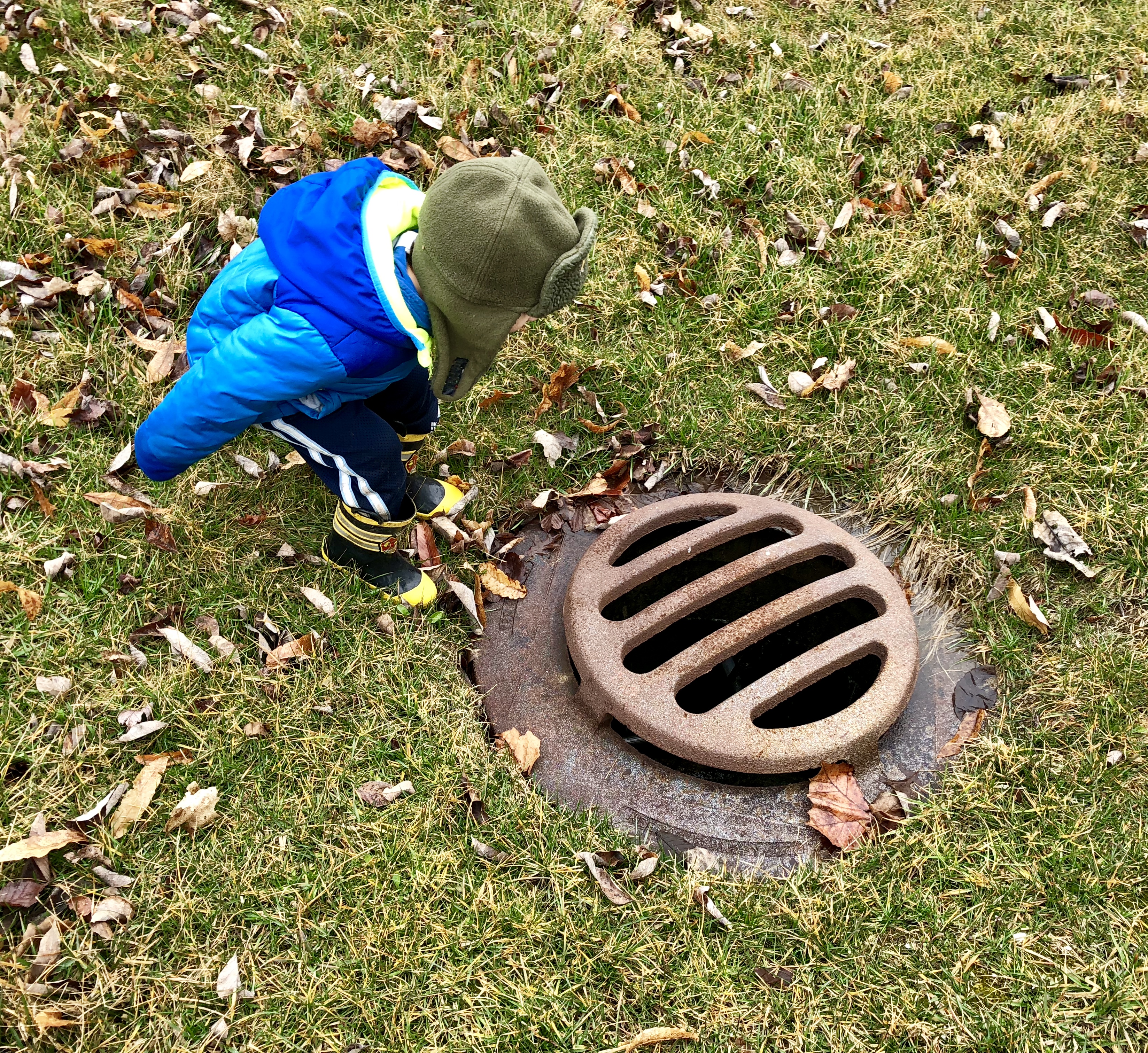 boy leaning over a drain similar to the first drain