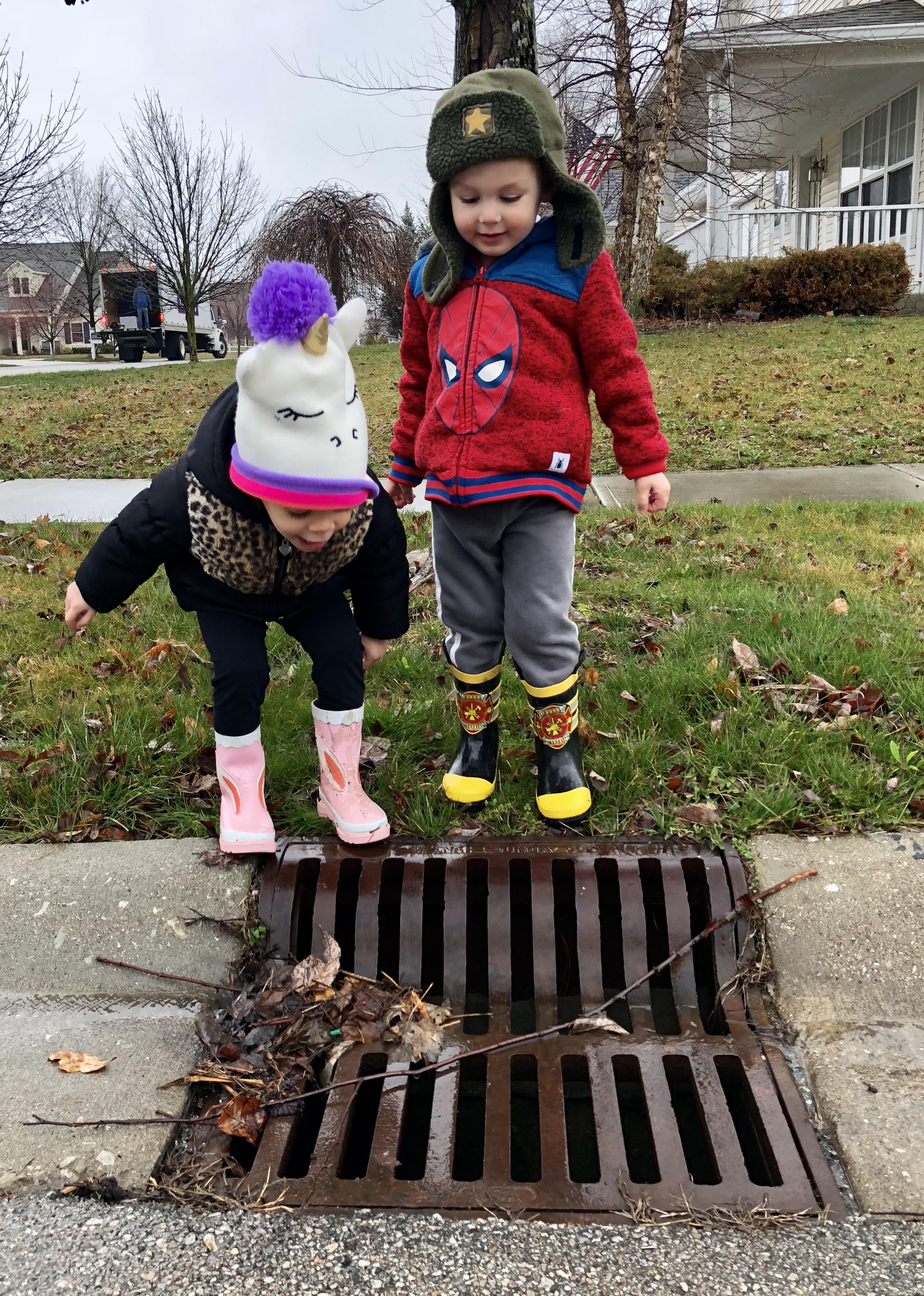boy and a girl shouting into a drain