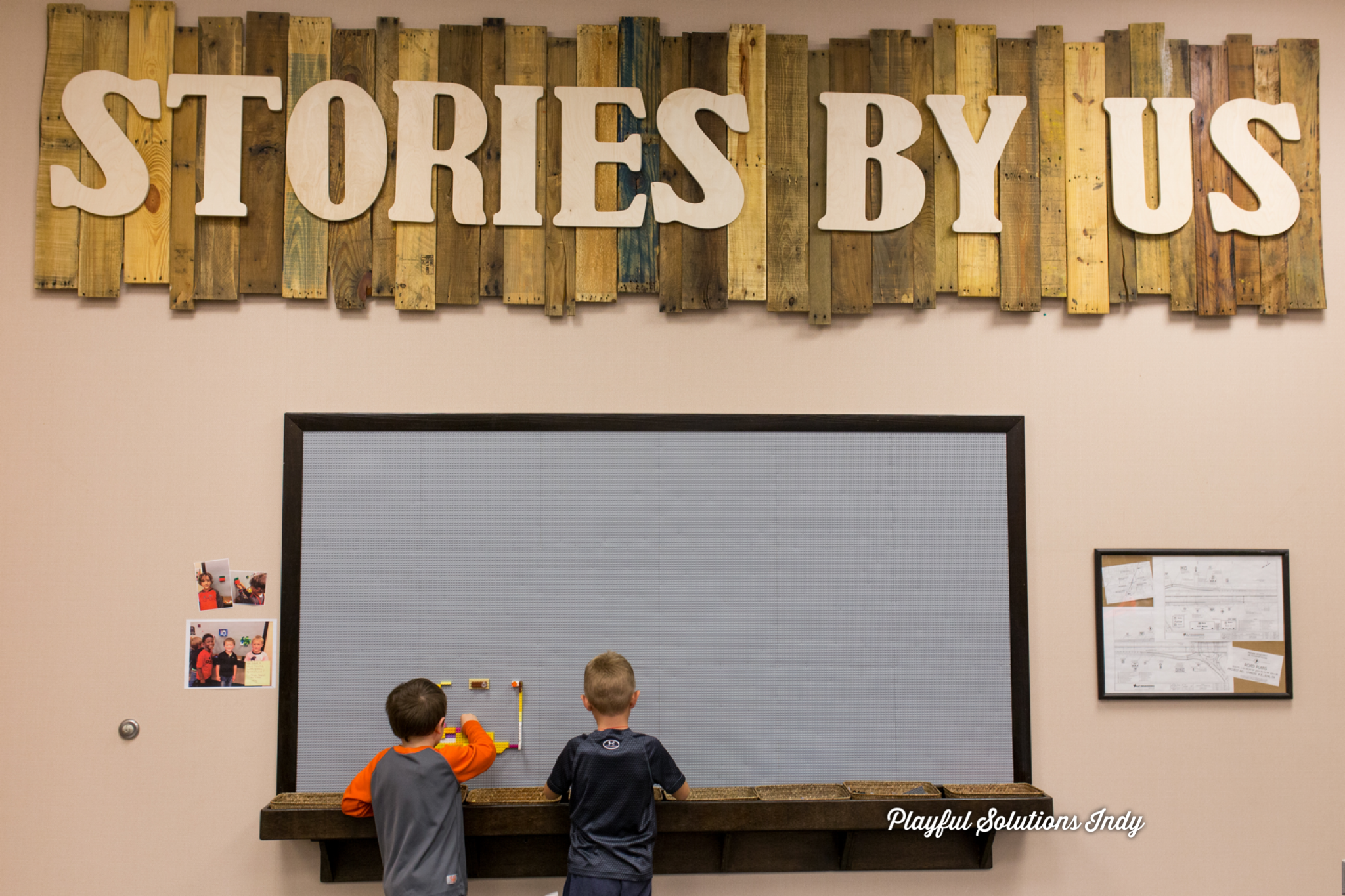 children building at the Lego wall under the Stories By Us sign