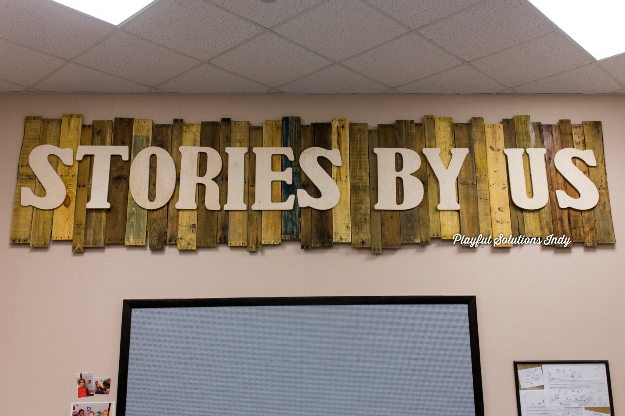 wooden sign with unfinished letters that spell out stories by us