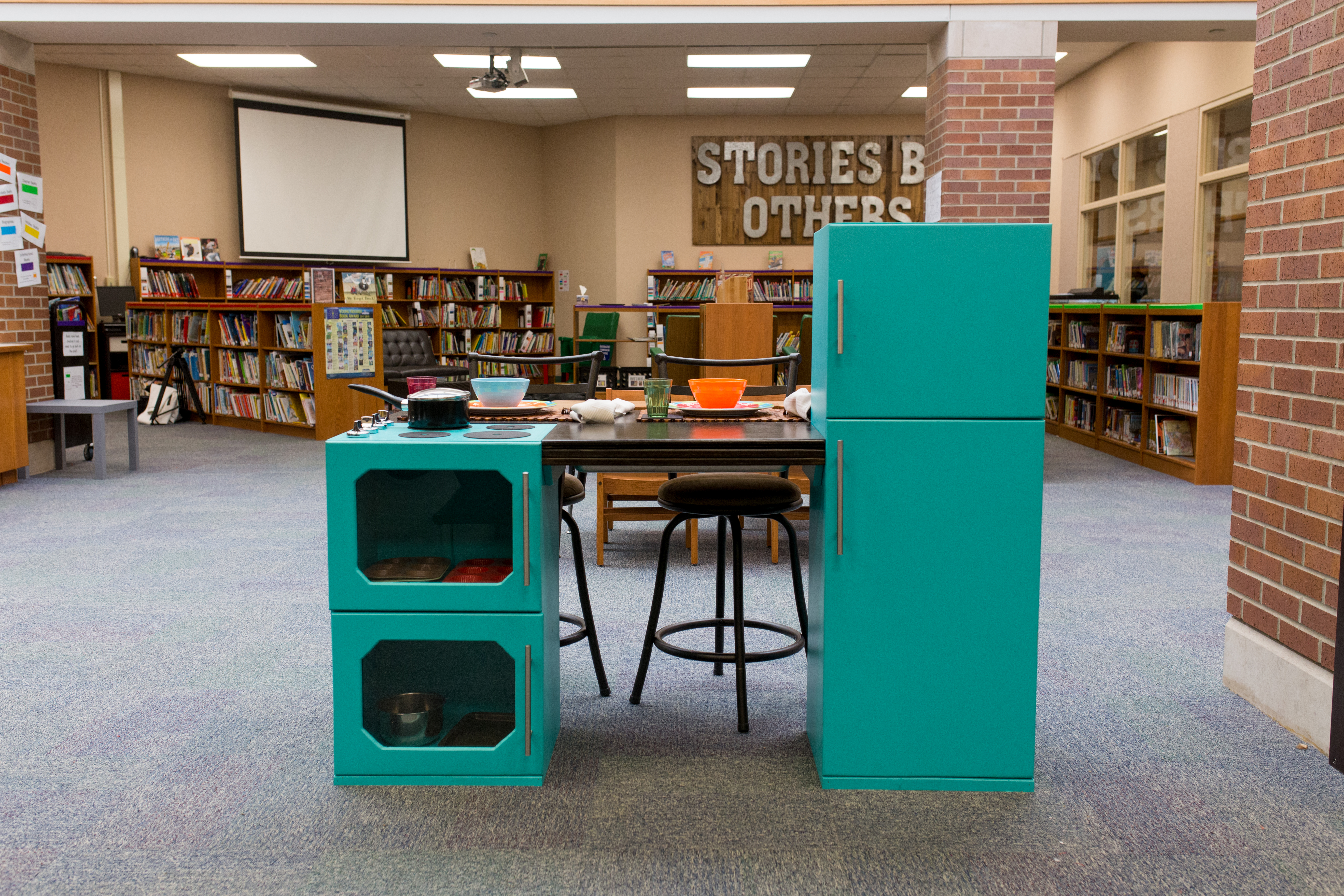 a custom play kitchen built out of wood and larger than most play kitchens available in stores