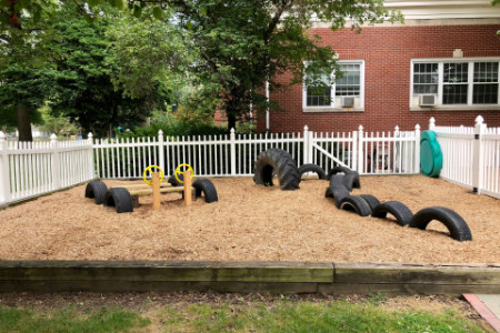 several tires and a car made from wooden beams embedded in mulch