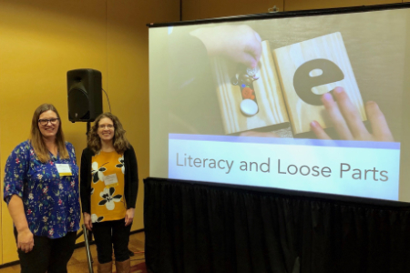 Crystal and another woman presenter standing by a screen displaying a slide presentation called Literature and Loose Parts